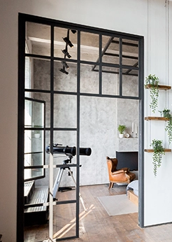 Türen im Loft-Stil mit schwarzen Metallrahmenelementen verbinden Küche und Wohnbereich.