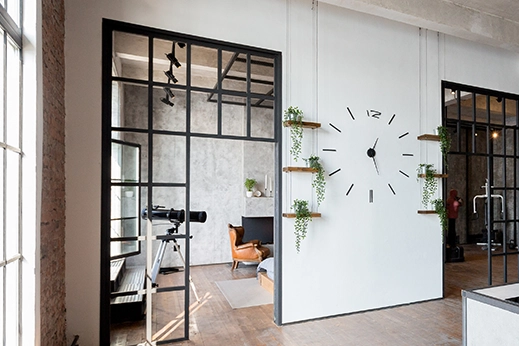 Türen im Loft-Stil mit schwarzen Metallrahmenelementen verbinden Küche und Wohnbereich.