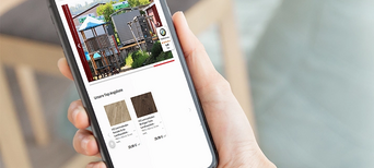 „Person hält Smartphone in der Hand und schaut auf die Website eines Holzfachhändlers mit Online-Shop.