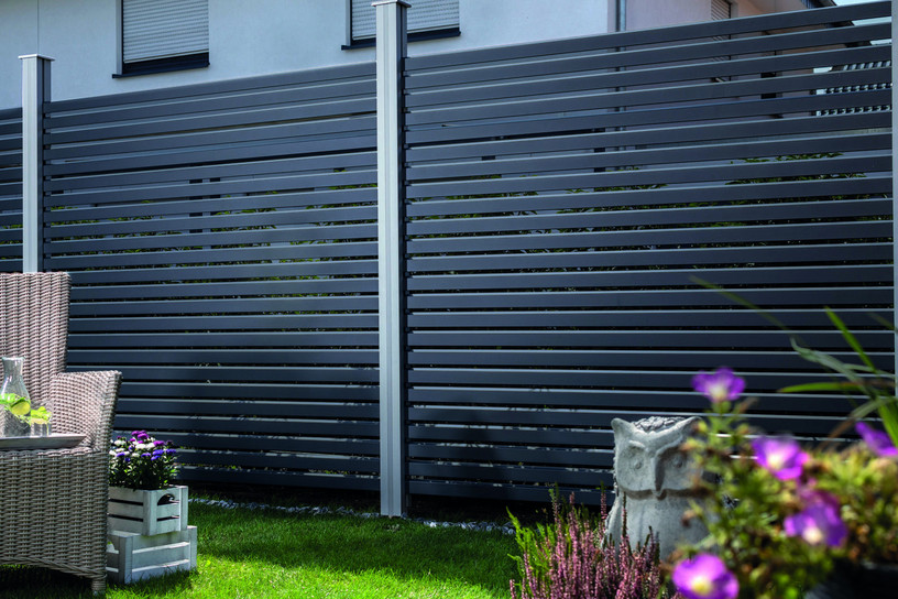 Moderner Alu-Rhombus-Sichtschutzzaun in Anthrazit mit stilvollem Gartenambiente und Loungesessel.