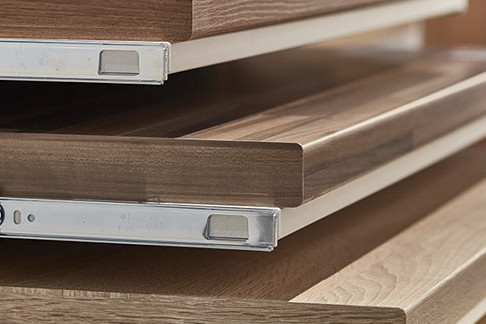 Gestapelte Holzarbeitsplatten mit Metallschienen, ideal für Küchen- und Möbelbau.